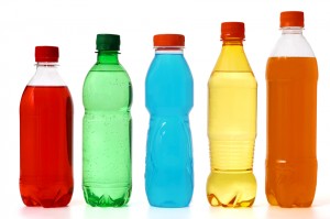 five colored bottles with juice and soda